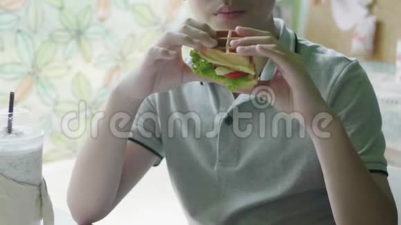 快乐的亚洲男孩喜欢在家吃汉堡包视频的预览图