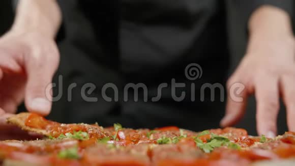 男人在黑色厨房里吃纯素披萨视频的预览图