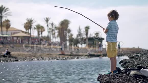 夏天小男孩正在海里钓鱼视频的预览图