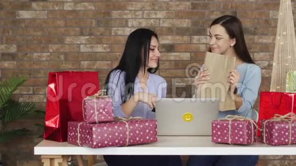 两个女朋友互相展示他们的购买黑色星期五概念视频的预览图