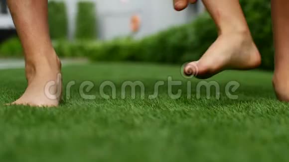 两个赤脚的人在绿草上2你的脚互相踩视频的预览图