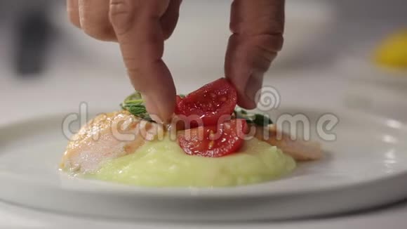 厨师手拿着一块红鱼鲑鱼和土豆泥用百里香装饰视频的预览图