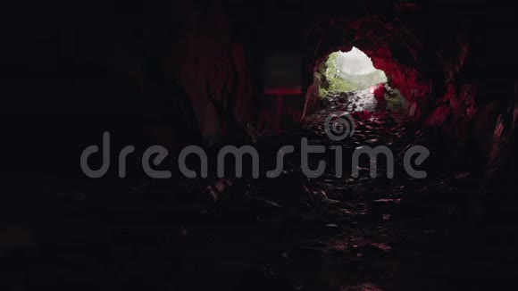 人走在洞穴里留下入口在他身后极端和运动的概念库存录像游客视频的预览图