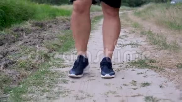 穿着蓝色运动鞋和黑色短裤的成年运动员在路上行走视频的预览图