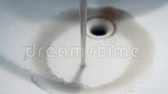 关闭从水槽中的水龙头流出的肮脏生锈的棕色污染水视频的预览图