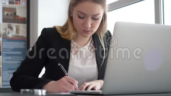 Smilimg金发女孩正在用她的笔记本电脑工作她是设计师女青年建筑师视频的预览图