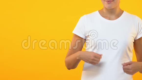 女士在橙色背景上显示广告或文字的空位置视频的预览图