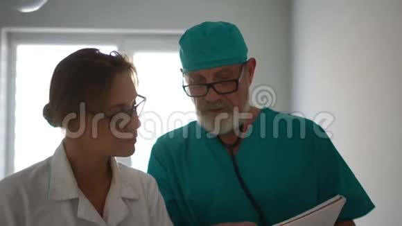 医生沿着诊所的走廊散步讨论工作问题动态视频女医生和男医生视频的预览图