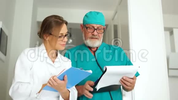两位医生一男一女正在诊所的走廊里交谈国际医生日医学和视频的预览图