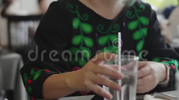 年轻的亚洲女人喝着带着微笑的脸的水视频的预览图