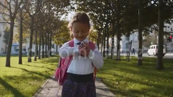 一个穿着校服的小女孩在智能手表上走来走去视频的预览图