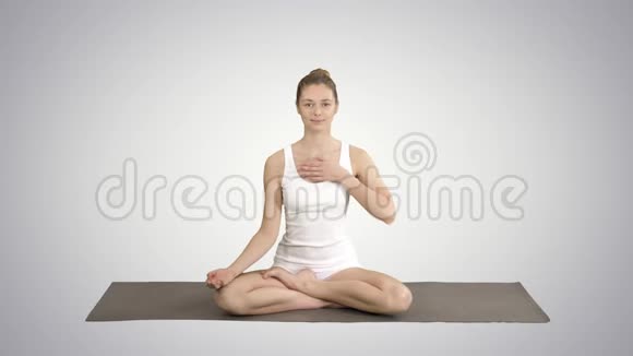 瑜伽女孩呼吸莲花姿势她的手在她的胃和胸部在梯度背景视频的预览图