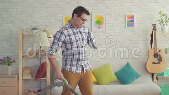 无手残疾的肖像青年正在用吸尘器打扫房子视频的预览图
