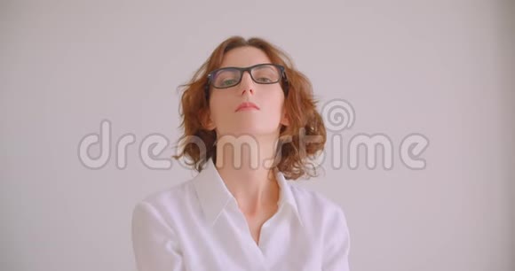 红发白种人女商人戴着眼镜自信地坐在扶手椅上看着摄像机的特写照片视频的预览图