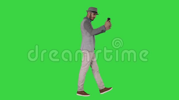 阿拉伯魅力男子穿着休闲服装录制视频博客绿色屏幕Chroma键视频的预览图