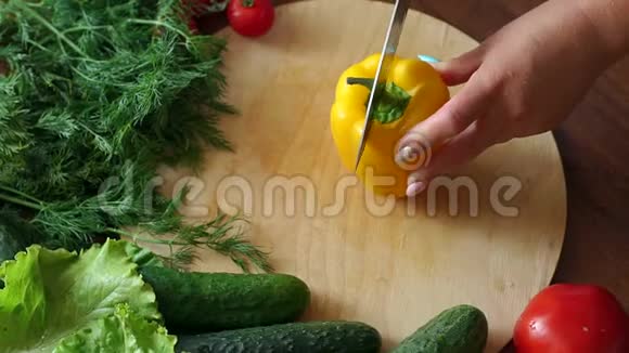 一个女人的特写在切割板上切成两半新鲜的黄色甜椒视频的预览图