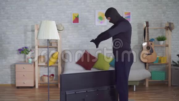 匿名小偷戴着巴拉克拉瓦面具在家里偷电视并遭受背痛视频的预览图