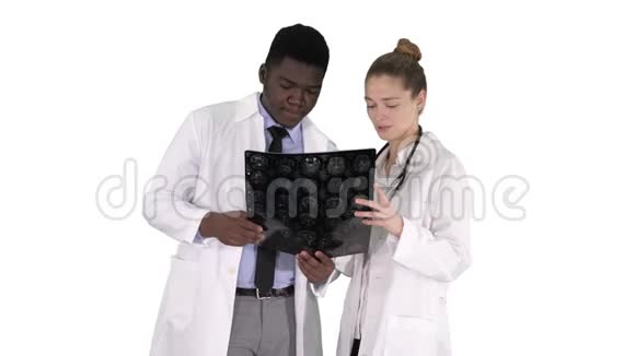 严肃善良的女医生和美国黑人医生在白色背景下研究大脑x光视频的预览图