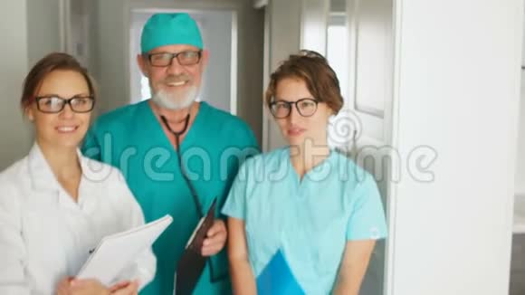 一个成熟的医生和他的两个助手的肖像医学和医疗保健概念微笑的医生亲密的肖像视频的预览图