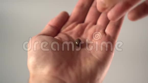 一只手从手掌上取出一个医用棕色胶囊视频的预览图
