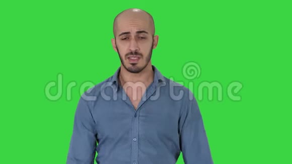 一名阿拉伯休闲男子在绿色屏幕上和摄像机边走边聊彩色键视频的预览图