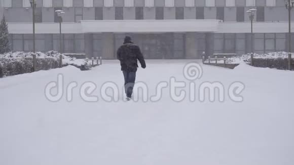 城里的一个人正在雪地里慢悠悠地走在街上视频的预览图