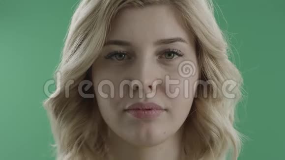 幸福的年轻女子微笑着亲吻绿色的屏幕视频的预览图