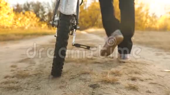 一辆自行车车轮正沿着道路滚动特写镜头慢动作孩子骑自行车旅行少年上路视频的预览图