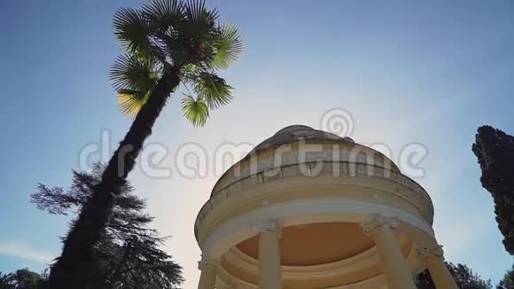 棕榈树附近阳光下的古董圆形大厅视频的预览图