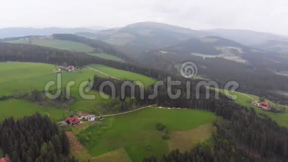 在雾天飞过奥地利青山上的一个小村庄视频的预览图