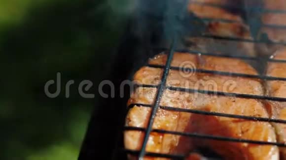 金鳟鱼烤牛排在炭火烤架上煎烤鲑鱼红鱼视频的预览图