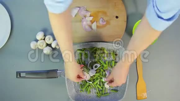 雌手把豆子放在平底锅里搅拌然后切蘑菇和洋葱时间圈视频的预览图