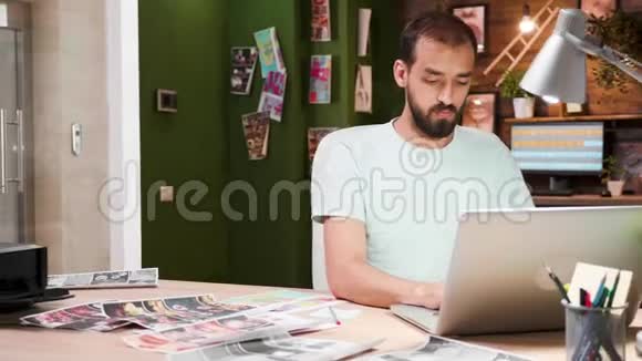 一位创意商人坐在办公室里用手提电脑打字视频的预览图