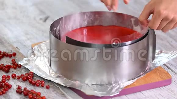 厨师从红醋栗的摩丝蛋糕上取出金属圈模具视频的预览图