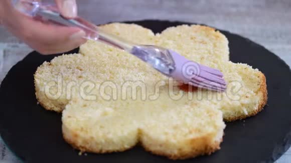 用糖浆浸泡海绵蛋糕层糕点厨师正在做一个粉红色的蛋糕形状像一朵花视频的预览图
