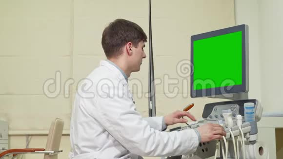 年轻男性医生使用绿色屏幕超声波扫描仪视频的预览图