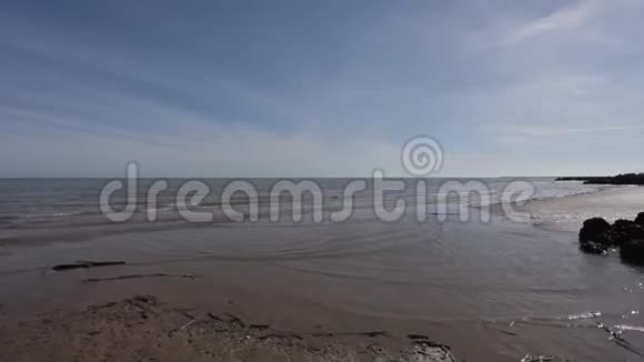 夏日里沙滩上被平静的海浪拍打的潘视频的预览图