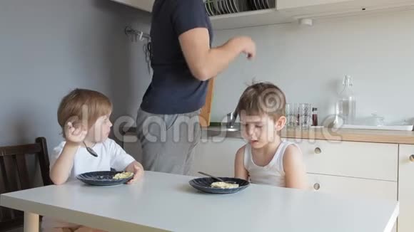 爸爸在孩子们吃早餐时给他们倒茶视频的预览图