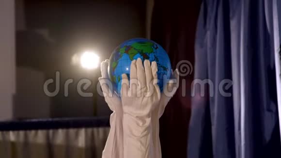 木偶剧院双手戴白色手套手握地球仪视频的预览图