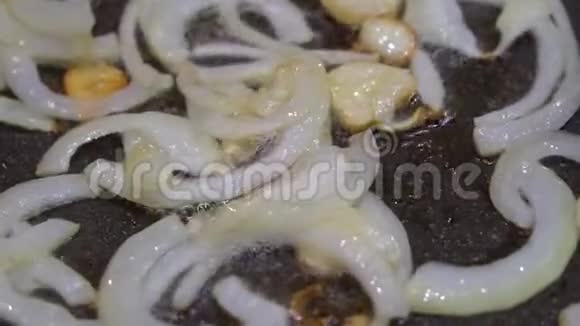 切好的洋葱放在锅里的植物油里炒厨房瓷砖上的特写视频的预览图