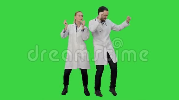 年轻的医生心情很好在绿色屏幕上跳舞和唱歌Chroma键视频的预览图