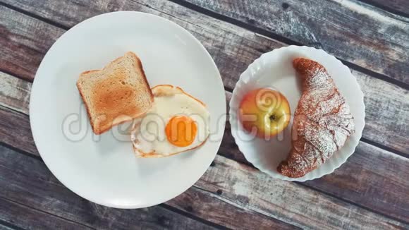 健康美味早餐煎蛋烤面包苹果和牛角面包视频的预览图