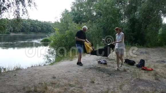 父女两人搭起帐篷准备在野外过夜绿色旅游徒步旅行快乐旅行的概念视频的预览图