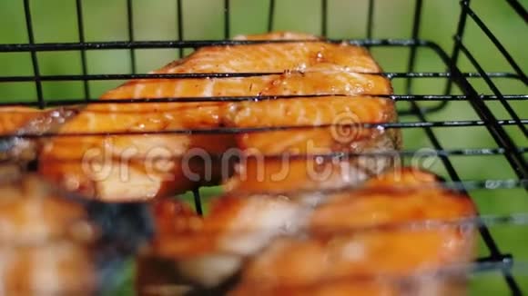 金鳟鱼在炭烤架上烤牛排烧烤时吃三文鱼视频的预览图