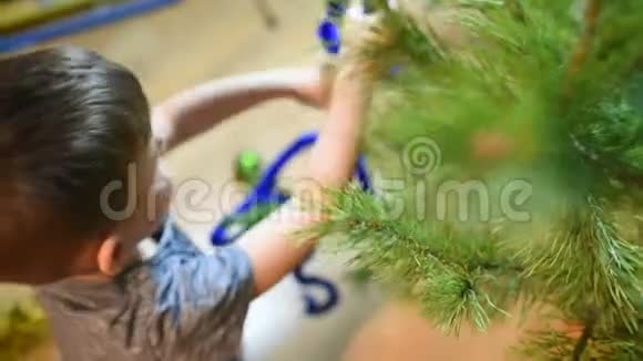 男孩在家里用玩具装饰圣诞树视频的预览图
