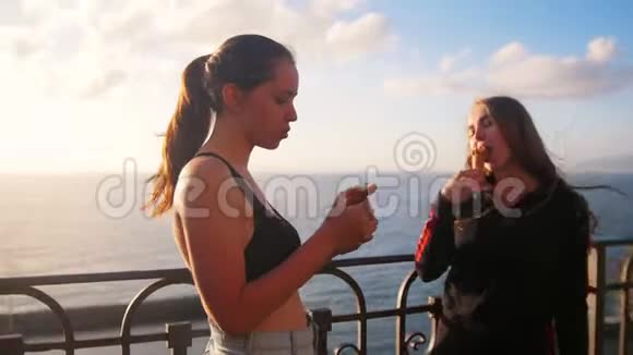 两个年轻女子站在海边码头训练后吃冰淇淋视频的预览图