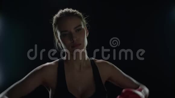 女战士用红色拳击手套踢手女拳击手的肖像视频的预览图