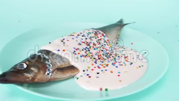时尚食品鲱鱼与莱茵石粉红色酱汁和五颜六色的纸屑视频的预览图