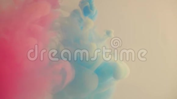 粉红色和蓝色的墨水倒入水中鲜艳颜色的颜料扩散彩色油漆慢慢溶解在水中视频的预览图