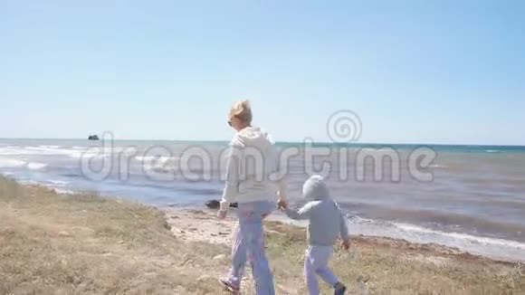 妈妈和儿子手拉手在海边散步视频的预览图